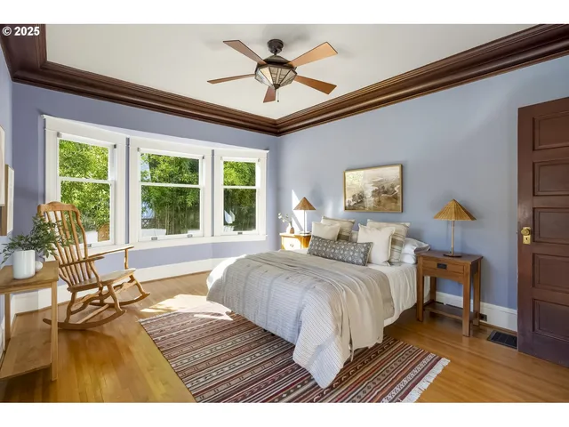 a bedroom with a bed and a large window with the view of balcony