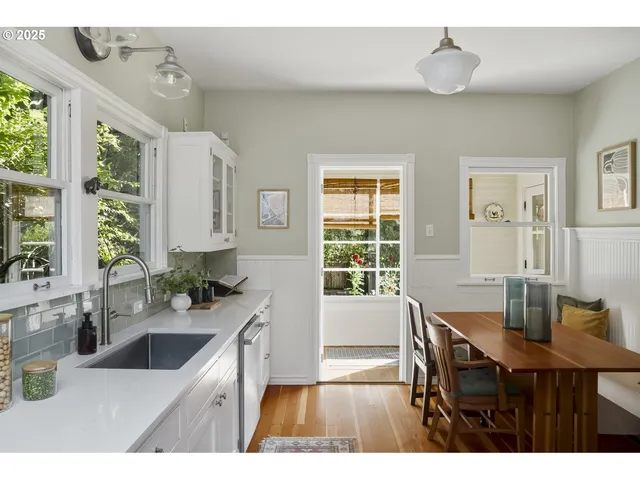 a kitchen with a dining table chairs and large window