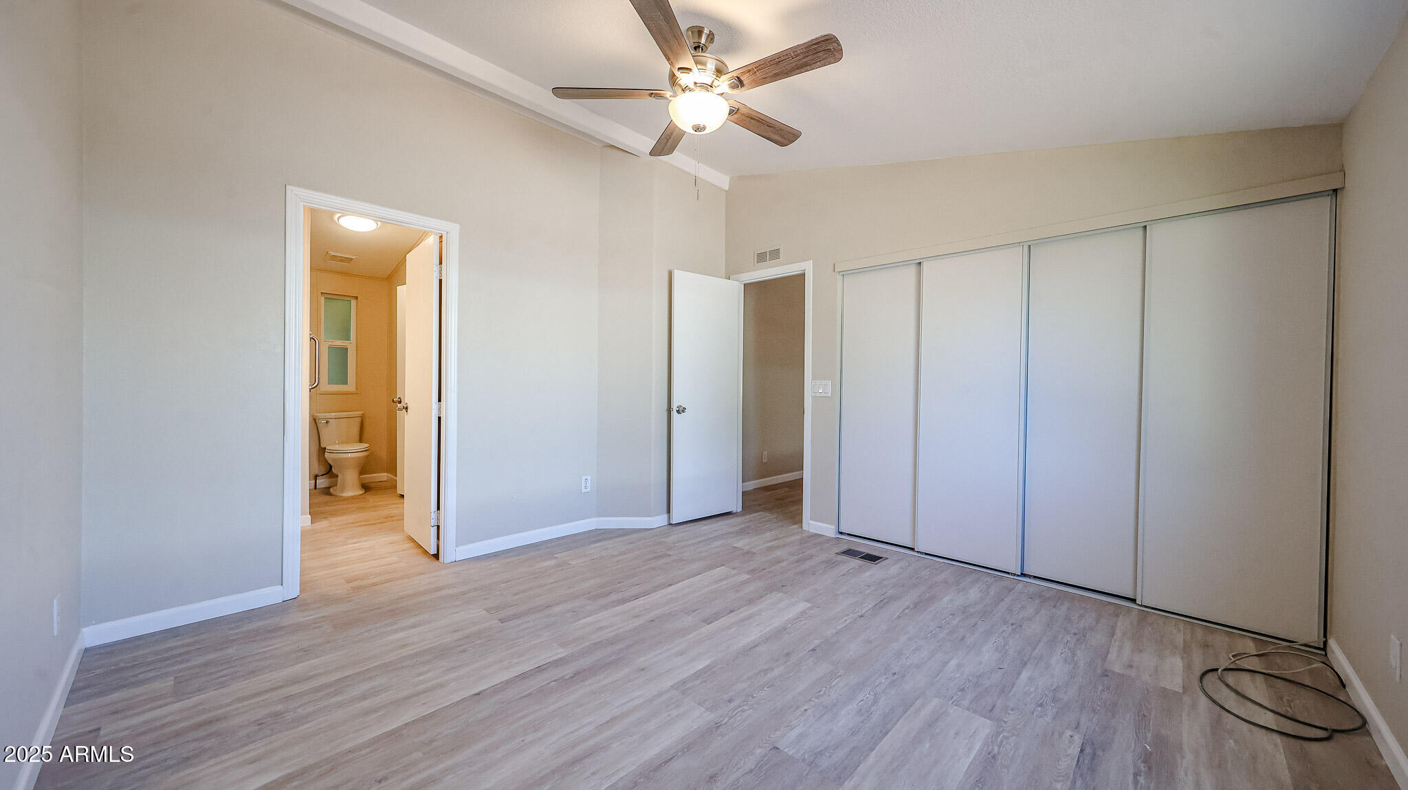 3901 East Pinnacle Peak Road, Unit 108 Phoenix, AZ 85050 - Photo 11 of 30 an empty room with wooden floor and a ceiling fan