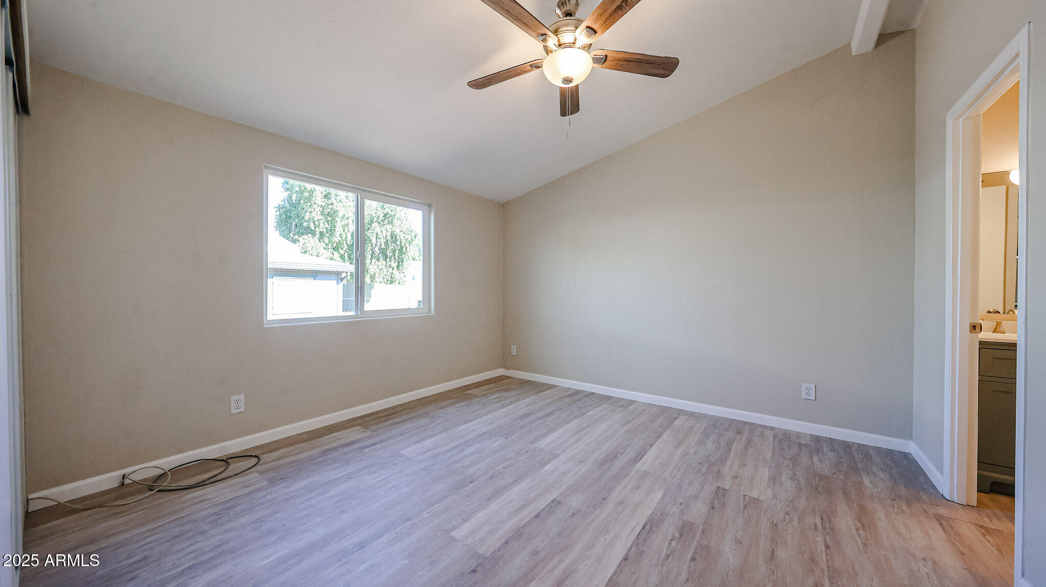 3901 East Pinnacle Peak Road, Unit 108 Phoenix, AZ 85050 - Photo 13 of 30 a view of an empty room with wooden floor and a window