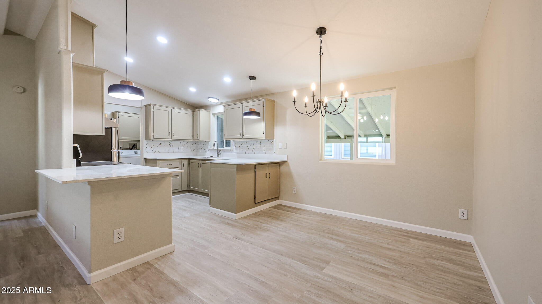 3901 East Pinnacle Peak Road, Unit 108 Phoenix, AZ 85050 - Photo 4 of 30 a large kitchen with kitchen island white cabinets and stainless steel appliances