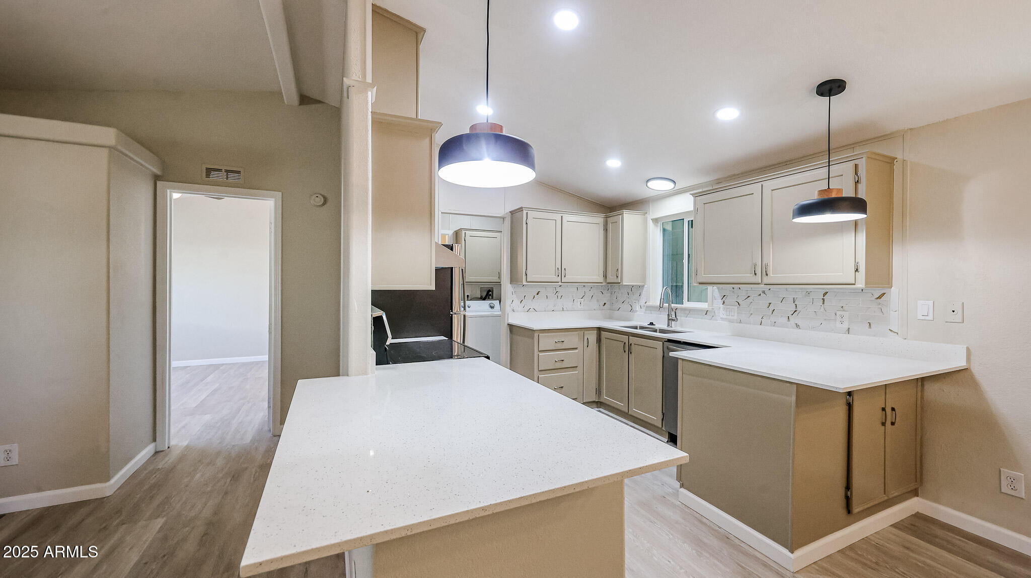 3901 East Pinnacle Peak Road, Unit 108 Phoenix, AZ 85050 - Photo 6 of 30 a large kitchen with kitchen island a sink stainless steel appliances and cabinets