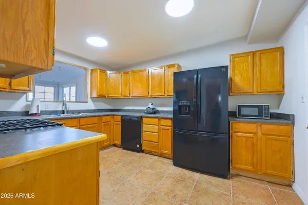 a kitchen with granite countertop stainless steel appliances a refrigerator cabinets and a sink