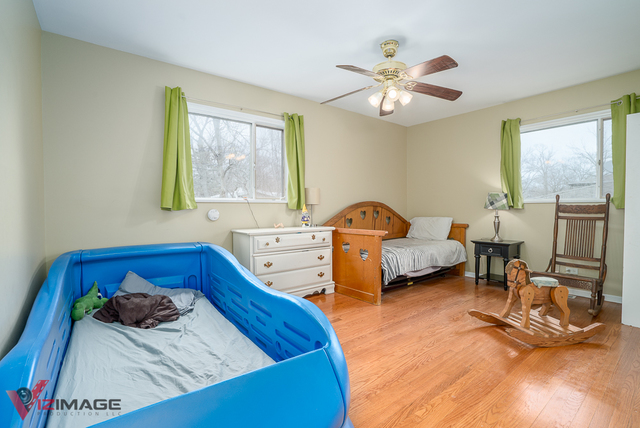 52 Monee Road Park Forest, IL 60466 - Photo 14 of 22 a bedroom with a bed and a chandelier