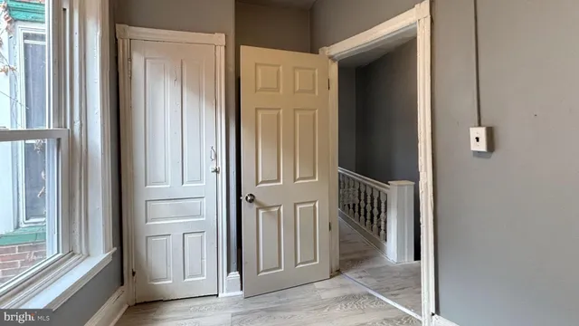 a view of a hallway with wooden floor and door