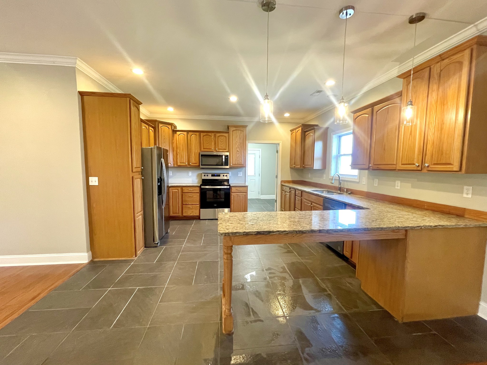 10591 Bell Station Road Oak Grove, KY 42262 - Photo 5 of 35 a large kitchen with stainless steel appliances a large counter top and a refrigerator