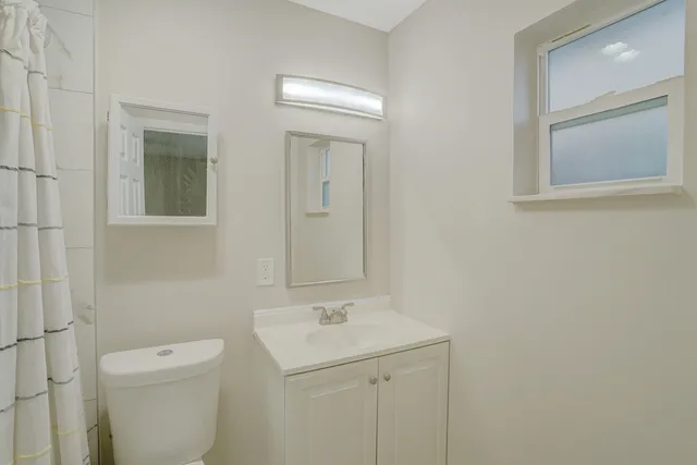 a bathroom with a toilet a sink and mirror