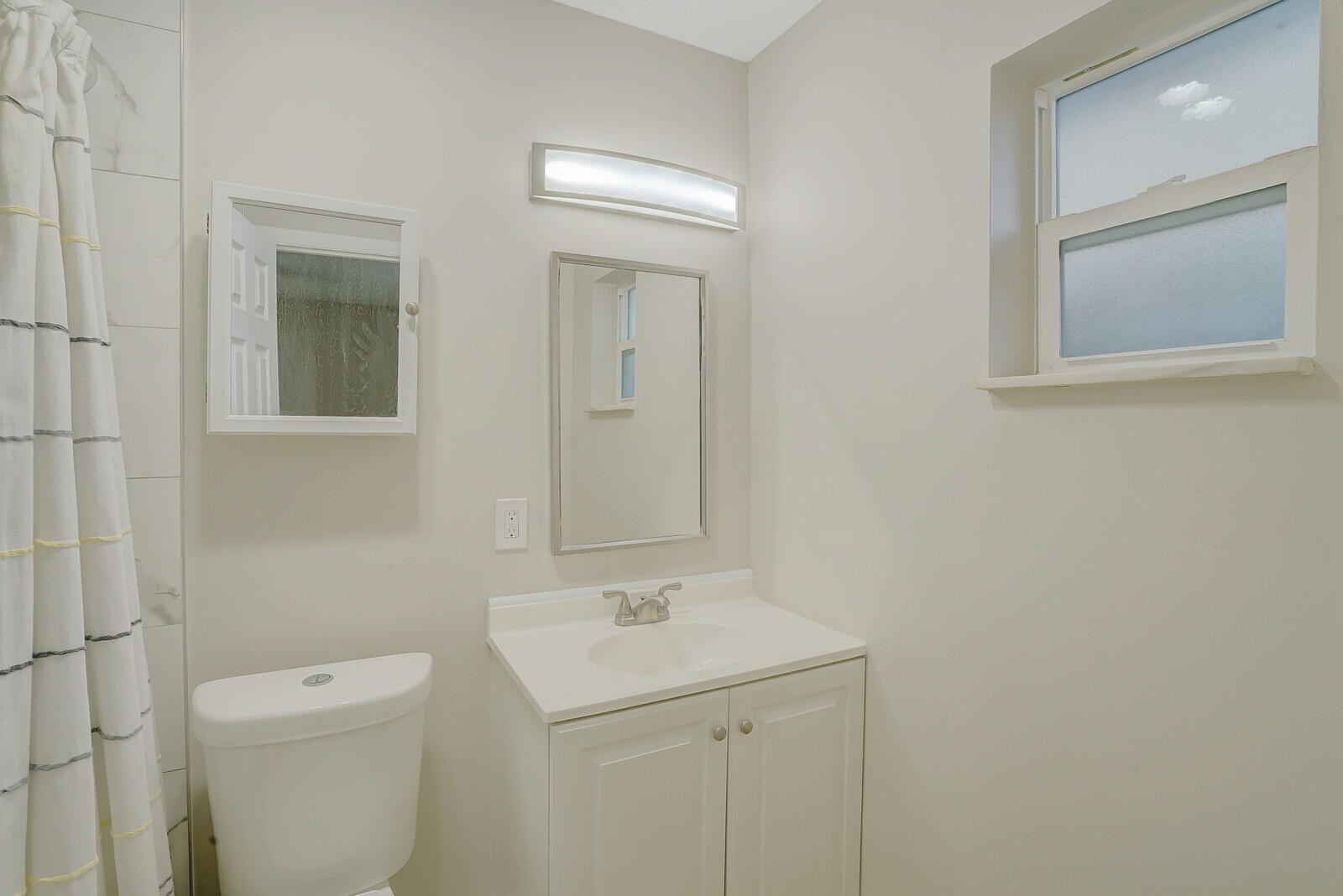 914 North Federal Highway, Unit 4 Lake Worth Beach, FL 33460 - Photo 13 of 18 a bathroom with a toilet a sink and mirror
