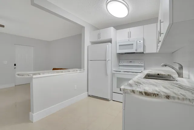 a utility room with cabinets washer and dryer