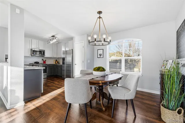a view of a dining room with furniture a chandelier and wooden floor