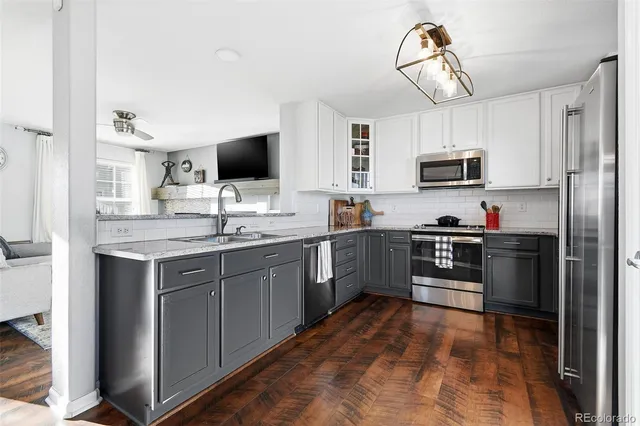 a kitchen with kitchen island granite countertop stainless steel appliances cabinets a sink and a counter top space