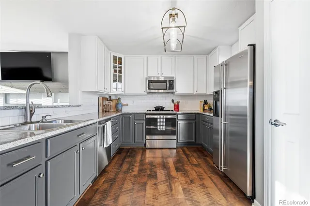 a kitchen with kitchen island a counter space a sink appliances and cabinets