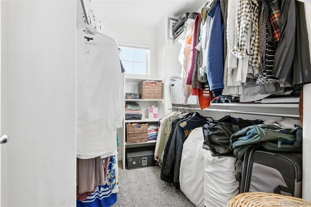 a view of walk in closet with clothes and shoes
