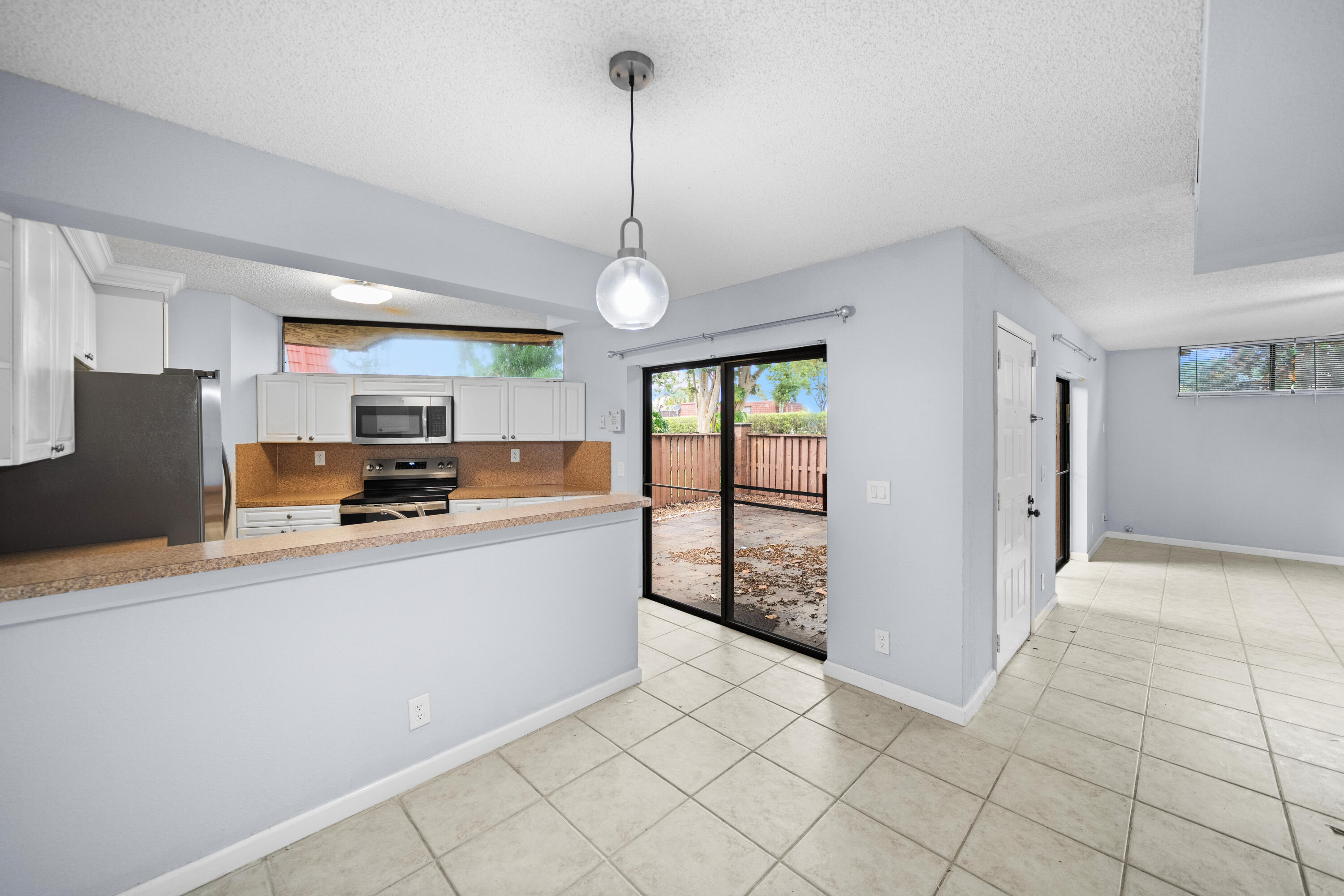 8237 Severn Drive, Unit A Boca Raton, FL 33433 - Photo 6 of 19 a large kitchen with stainless steel appliances granite countertop a refrigerator and a stove top oven