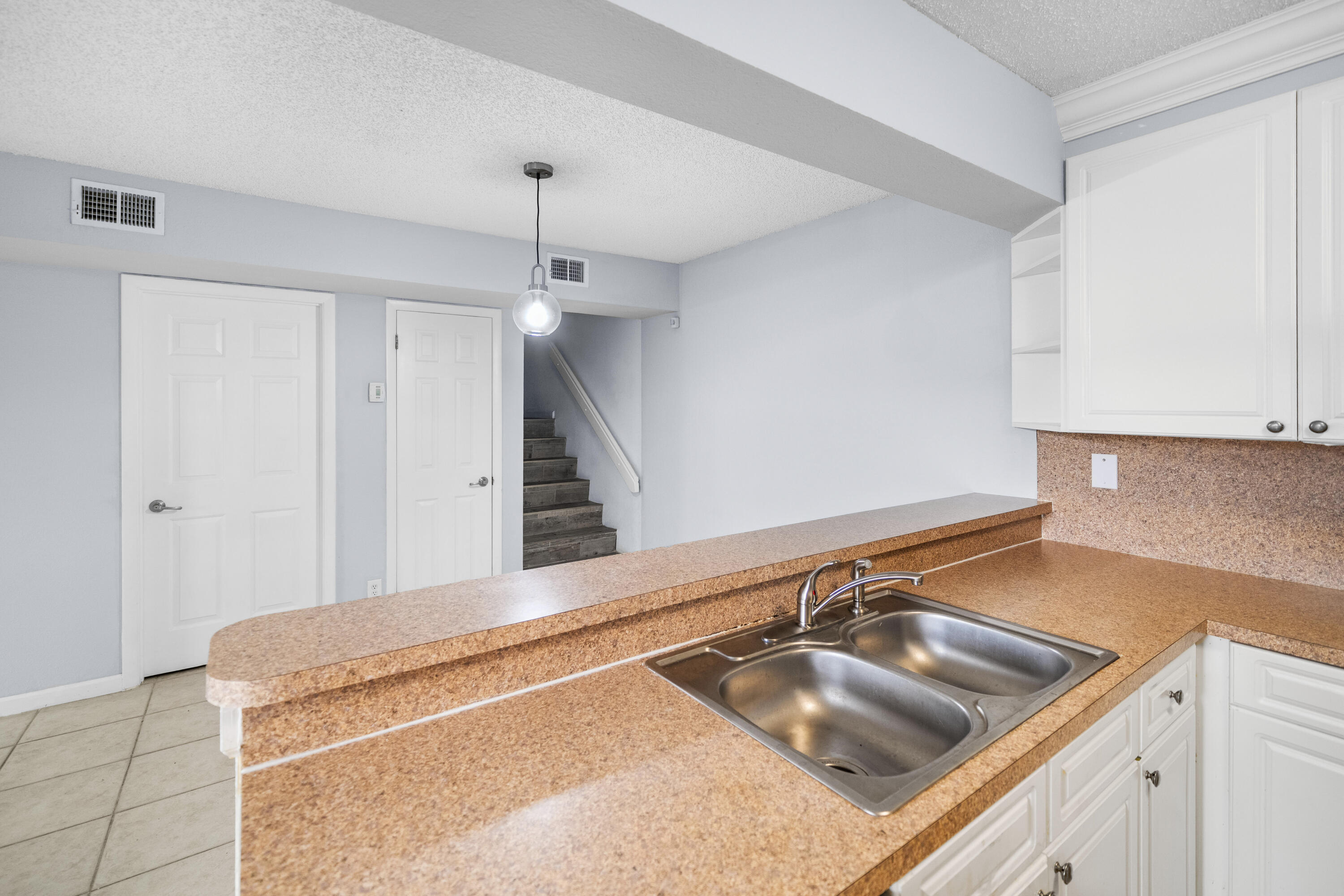 8237 Severn Drive, Unit A Boca Raton, FL 33433 - Photo 7 of 19 a kitchen with a sink a counter top space and cabinets