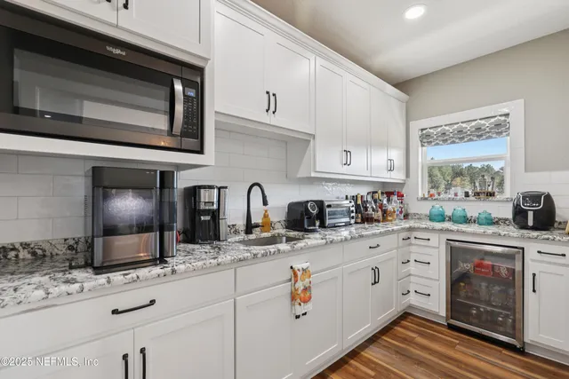 a kitchen with stainless steel appliances granite countertop a sink and cabinets with wooden floor