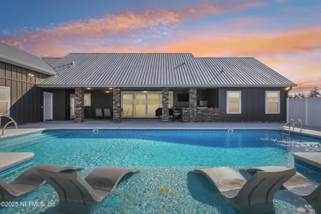 a view of a house with backyard patio and swimming pool