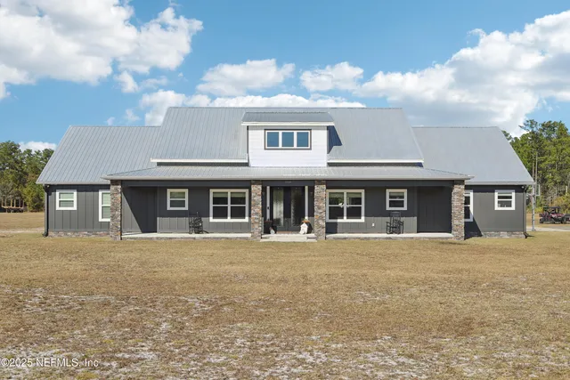a front view of a house with yard and tress