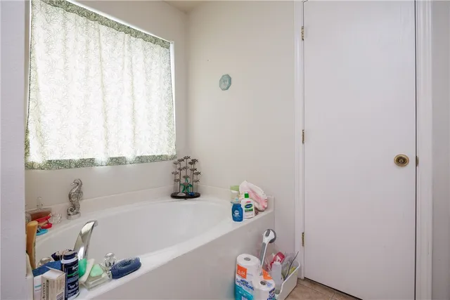 a bathroom with a tub a sink and a window