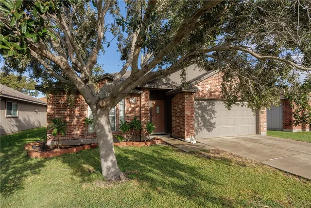 a view of a house with a tree and a yard