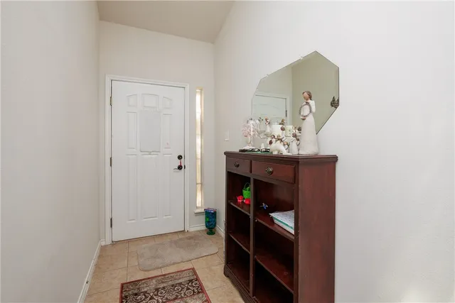 a view of a hallway to room with wooden floor and cabinet
