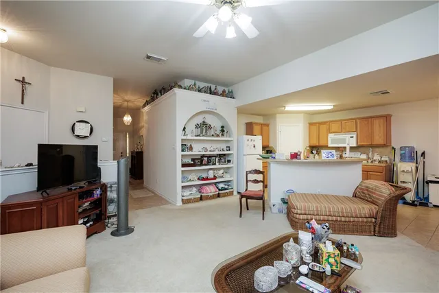 a living room with furniture and a flat screen tv with kitchen view