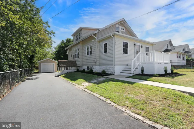 a front view of house with yard and trees in the background