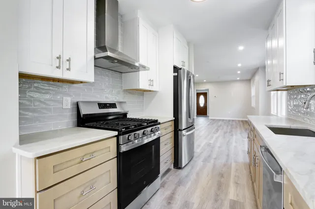 a kitchen with stainless steel appliances granite countertop a stove and a sink