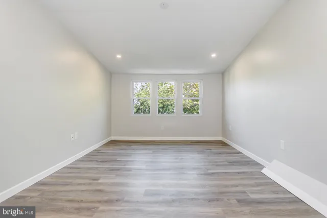 a view of a room with wooden floor and a ceiling fan