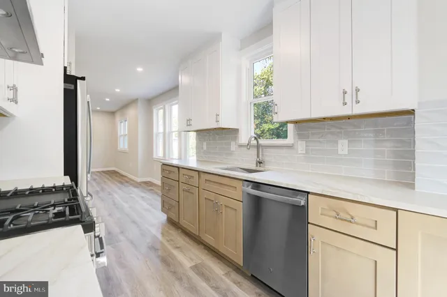 a kitchen with stainless steel appliances granite countertop a sink stove and cabinets