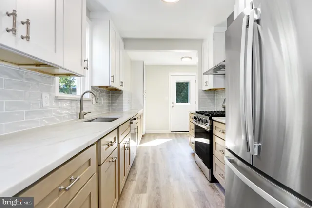 a kitchen with stainless steel appliances a sink stove and refrigerator