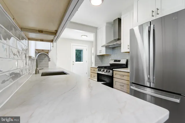 a kitchen with stainless steel appliances a refrigerator sink and stove