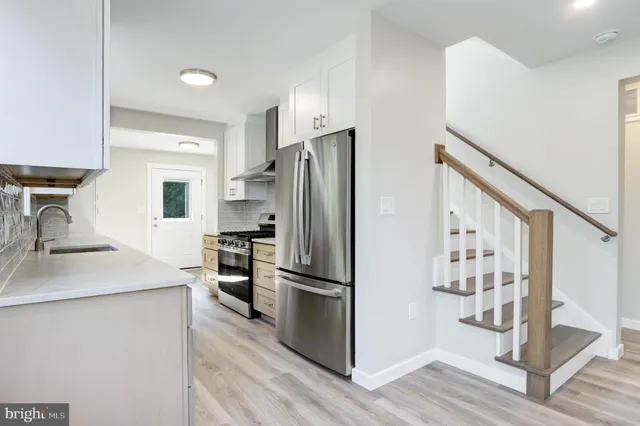 a kitchen with granite countertop a refrigerator and a sink