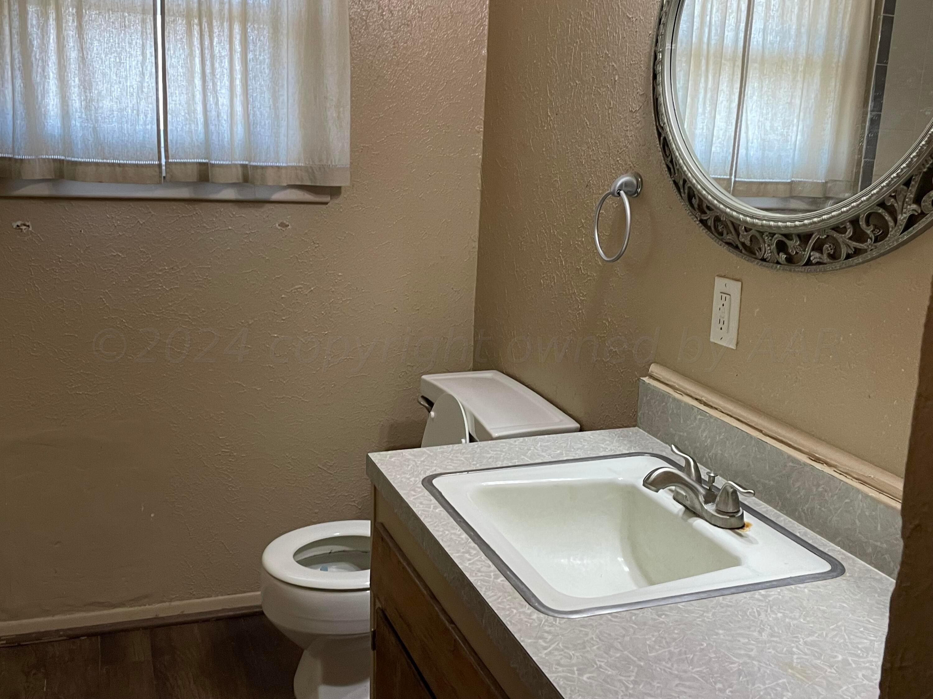 2014 South Drake Street Perryton, TX 79070 - Photo 9 of 10 a bathroom with a sink and a mirror
