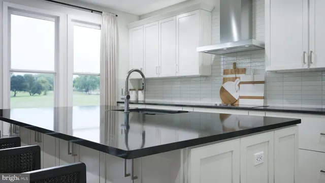 a kitchen with kitchen island a counter space a sink a window and cabinets