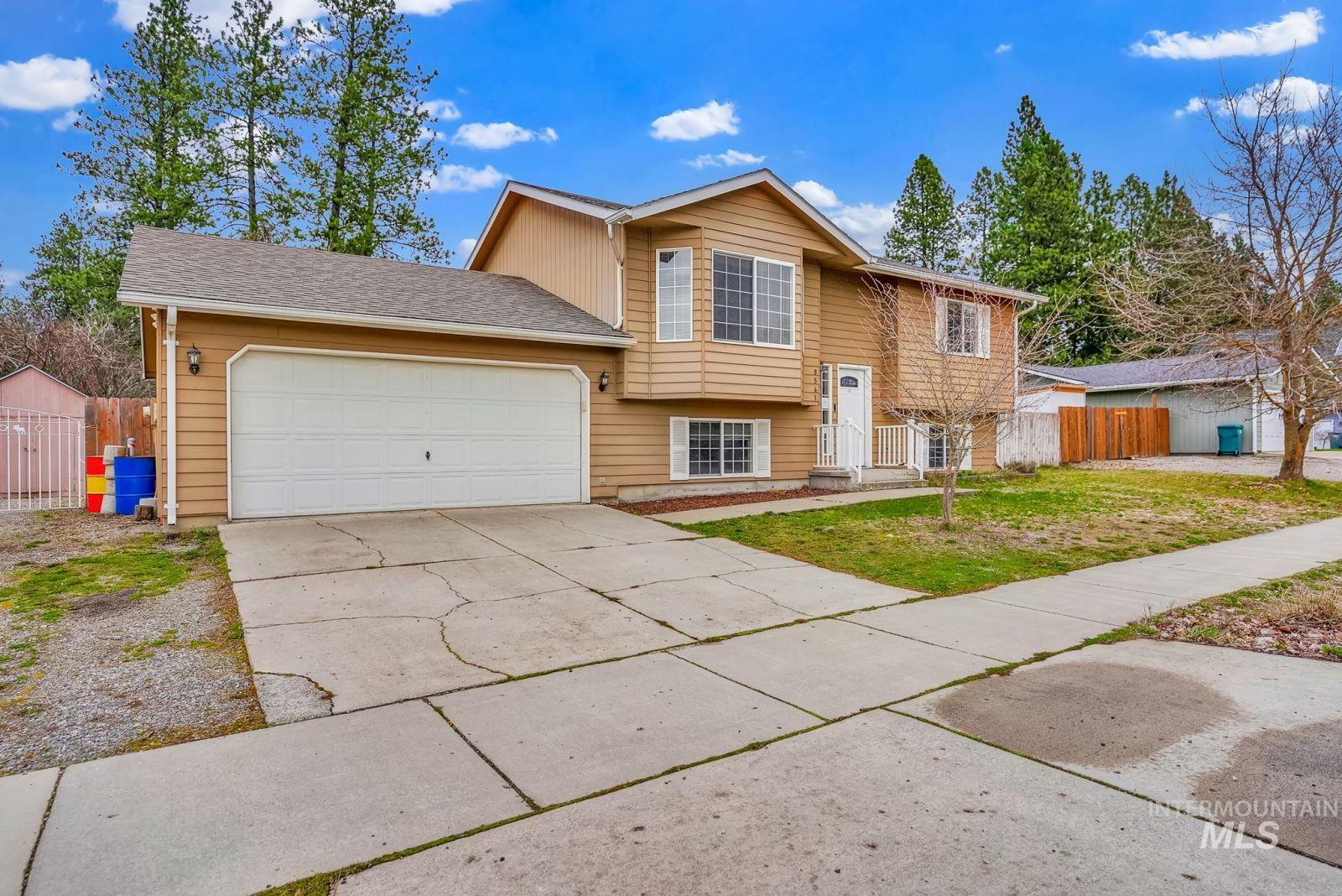 8561 Nebraska Street Rathdrum, ID 83858 - Photo 1 of 50 Raised ranch featuring an attached garage, driveway, and roof with shingles