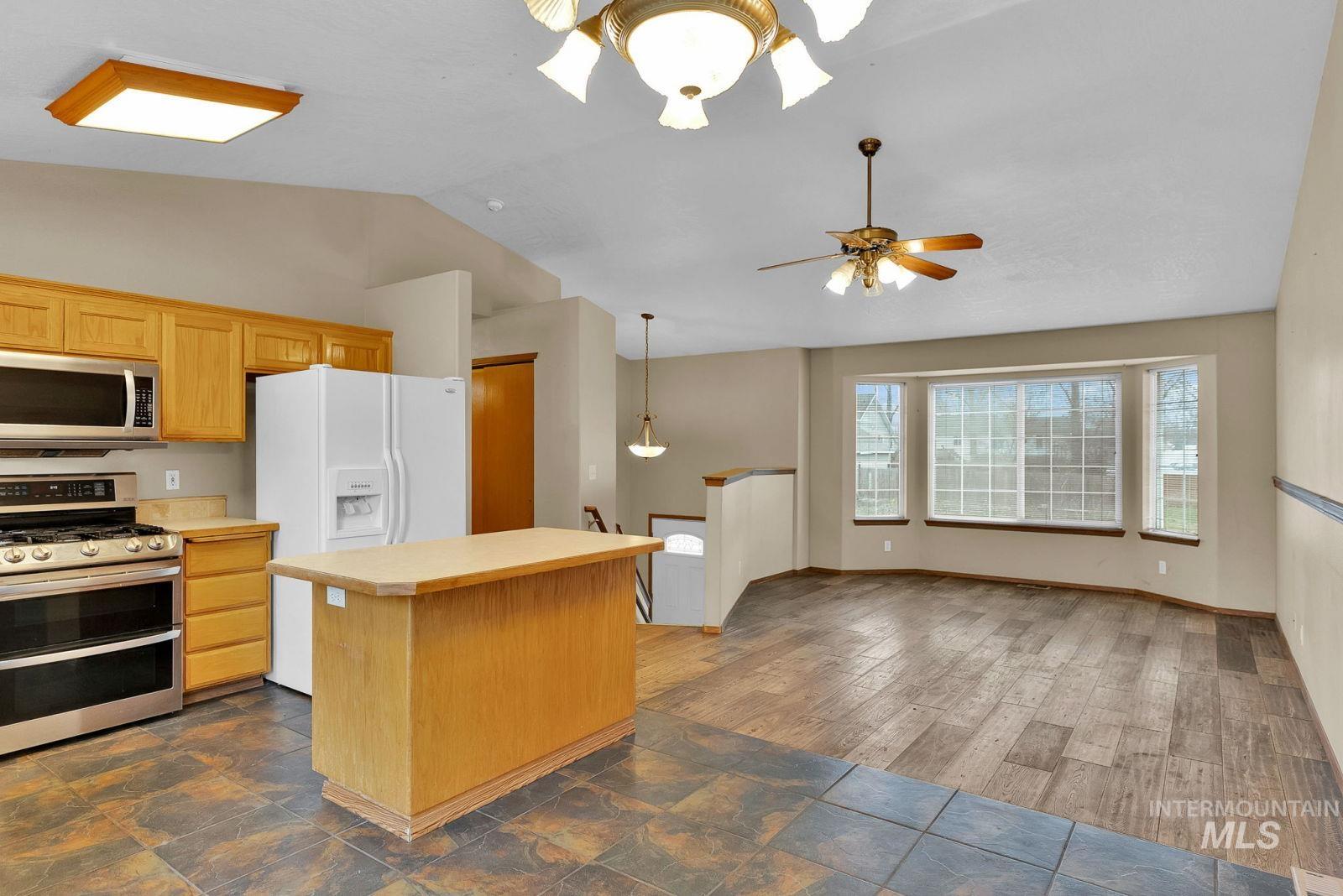 8561 Nebraska Street Rathdrum, ID 83858 - Photo 11 of 50 Kitchen with stainless steel appliances, light countertops, a kitchen island, vaulted ceiling, and pendant lighting