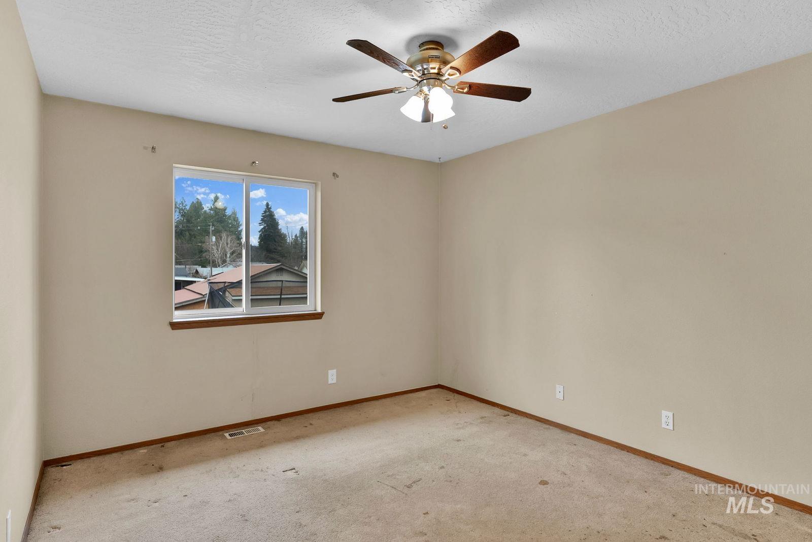 8561 Nebraska Street Rathdrum, ID 83858 - Photo 16 of 50 Empty room featuring light colored carpet, a textured ceiling, and a ceiling fan