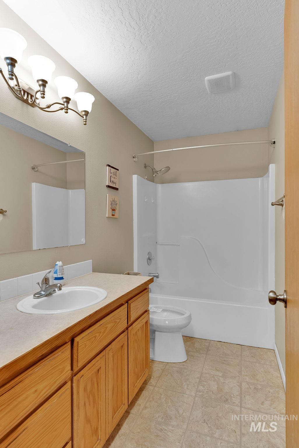 8561 Nebraska Street Rathdrum, ID 83858 - Photo 21 of 50 Bathroom featuring vanity, shower / tub combination, and a textured ceiling