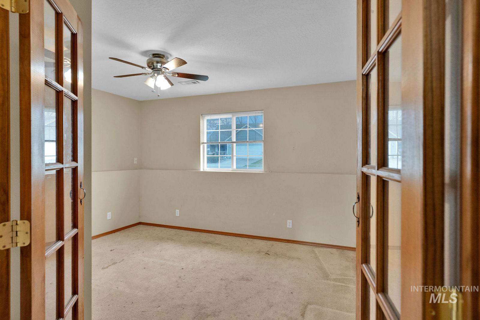 8561 Nebraska Street Rathdrum, ID 83858 - Photo 33 of 50 Spare room featuring ceiling fan, light colored carpet, and french doors