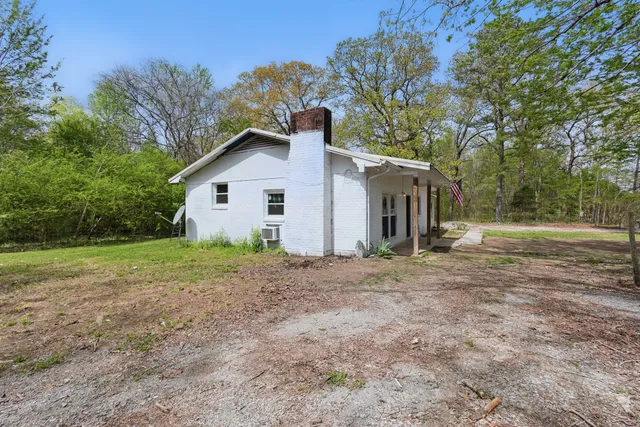 a backyard of a house with table and chairs