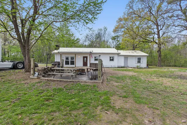 a view of a house with backyard and sitting area