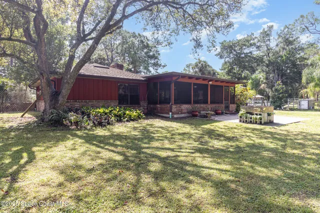 a view of a house with backyard and tree