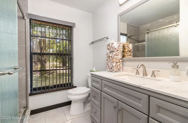 a bathroom with a granite countertop toilet sink and mirror