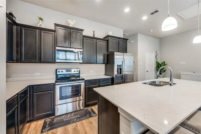 a kitchen with stainless steel appliances a stove refrigerator sink and cabinets