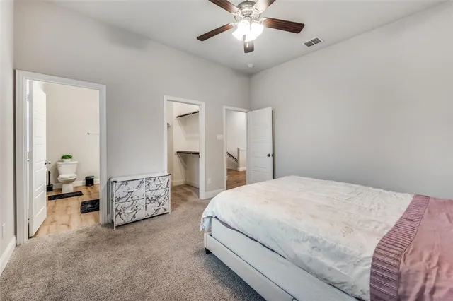 a spacious bedroom with a bed and a chandelier