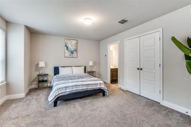 a spacious bedroom with a bed and a cabinets