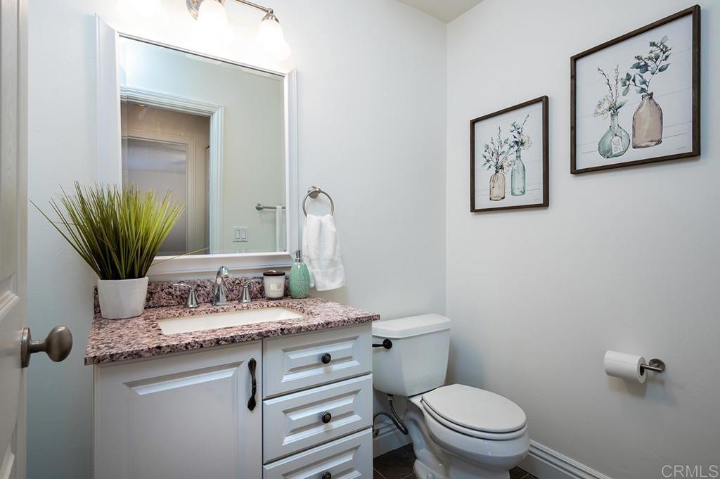 3688 1st Avenue, Unit 15 San Diego, CA 92103 - Photo 14 of 35 a bathroom with a granite countertop toilet sink and mirror