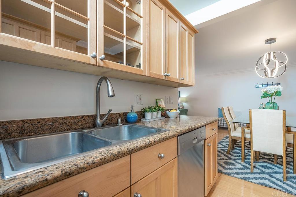3688 1st Avenue, Unit 15 San Diego, CA 92103 - Photo 8 of 35 a kitchen with stainless steel appliances granite countertop a sink a stove and a microwave oven with white cabinets