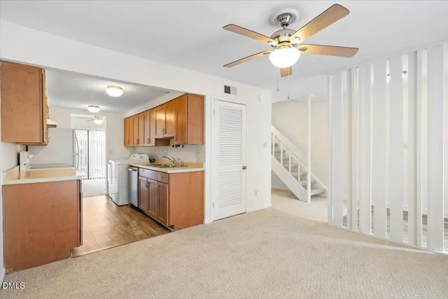 a living room with furniture and a dining table with kitchen view